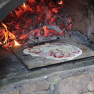 Leckere Pizza im Steinofen mit Feuer