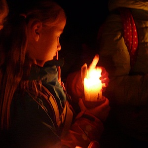 Die Wölflinge tragen eine Kerze durch die Dunkelheit auf ihrem Heimweg.