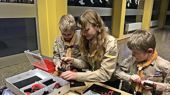 Zwei Kinder bauen Zahnräder zusammen.